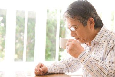 Yakışıklı, emekli bir Japon 'un sabah kahvesini yudumlarken çekilmiş portresi.
