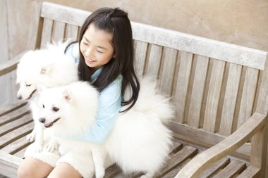 Küçük Asyalı kız ve iki sevimli köpeği.