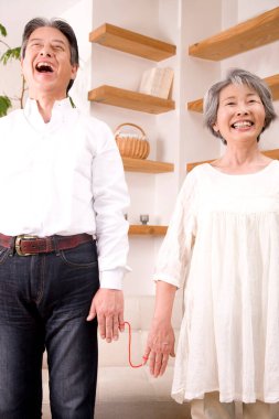 Evde gülümseyen kıdemli mutlu Asya çift