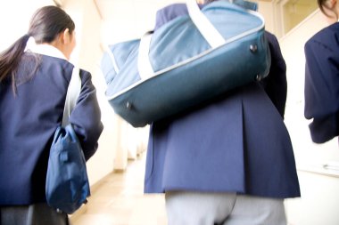 Genç adam ve kadın koridorda yürüyorlar. 