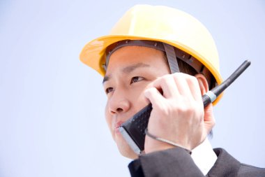 Genç Asyalı mimar telsizle konuşuyor.