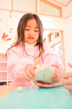 Anaokulunda kille oynayan sevimli Asyalı çocuk.