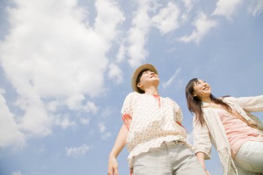 Sahada yürüyen iki genç Asyalı kadın.