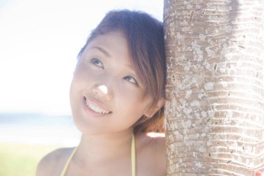 Güzel genç Japon kadın yaz tatili boyunca deniz kıyısında dinleniyor.