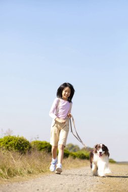 Şirin, mutlu Japon kızın yavru köpeğiyle portresi.