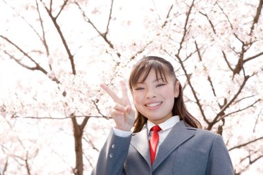 Genç Asyalı zafer işareti gösteriyor.