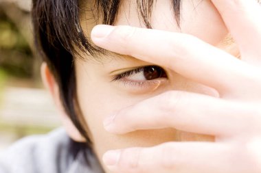 Genç Asyalı adam parmaklarından bakıyor.