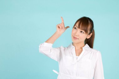 Güzel, genç Asyalı bir kadın mavi arka planda izole edilmiş.