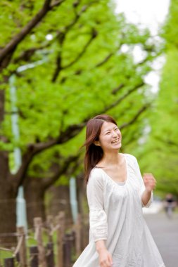 Güzel, mutlu, Asyalı bir kadının açık havada portresi.