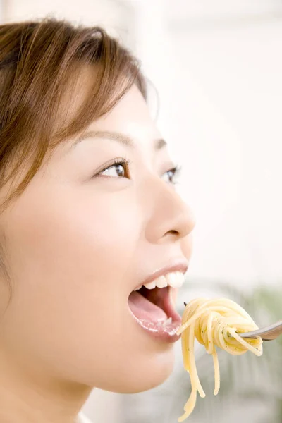 亚洲女人用叉子吃意大利面 — 图库照片