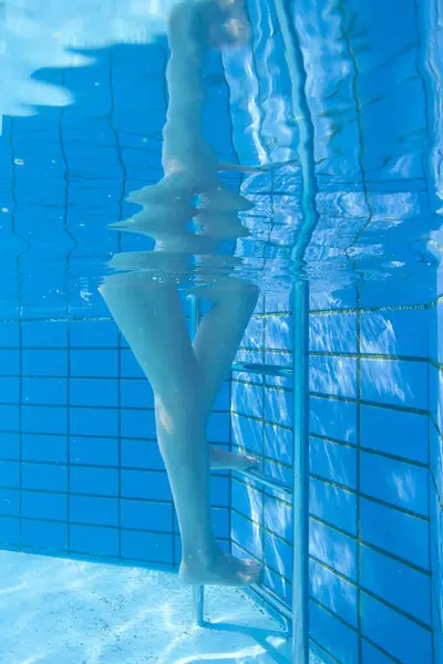 female swimmer in swimming pool, underwater view