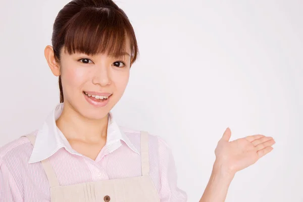 Młoda Azjatycka Kelnerka Pokazuje Coś Odosobnionym Tle — Zdjęcie stockowe