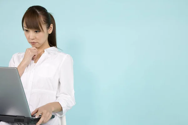 Asyalı Güzel Bir Kadın Dizüstü Bilgisayar Kullanıyor Mavi Arka Planda — Stok fotoğraf