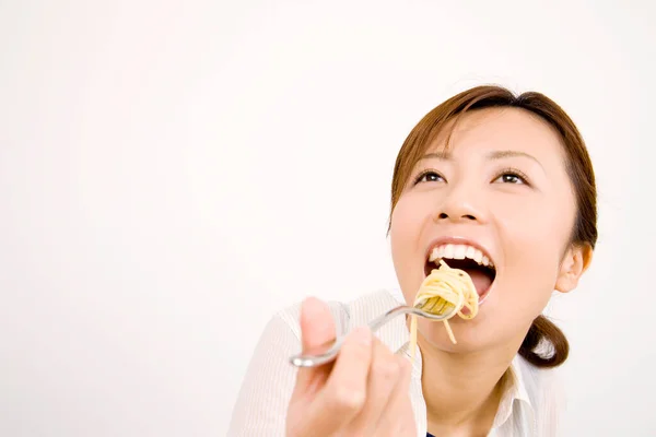 亚洲女人用叉子吃面条 — 图库照片