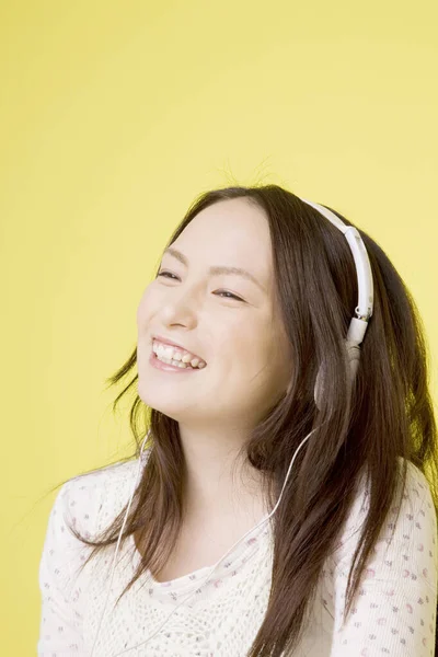 Портрет Красивой Японской Женщины Слушающей Музыку Наушниках Желтом Фоне — стоковое фото
