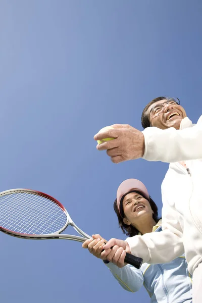 一緒にテニスをする幸せなアジアのシニアカップル — ストック写真