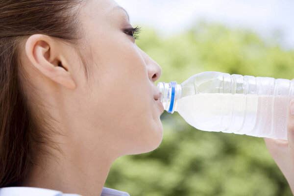 young Asian woman drinking water 