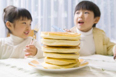 Mutlu Asyalı çocuklar krep yiyor.