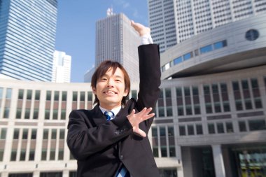 Sokakta elini kaldıran genç bir iş adamı.