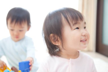 İki küçük bebek oyuncaklarla oynuyor. 