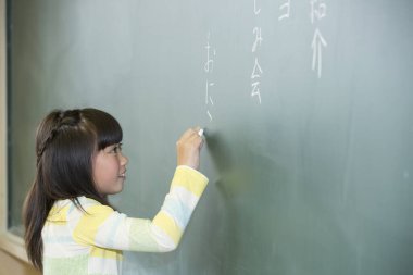 Kız sınıfta kara tahta üzerinde yazma