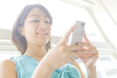 Akıllı telefonu olan genç bir kadın.