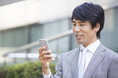 Akıllı telefon kullanarak Asyalı işadamını kapatın.