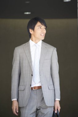 Genç Asyalı işadamı yürüyor ve gülümsüyor