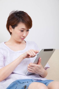 Evde dijital tablet kullanan kadın