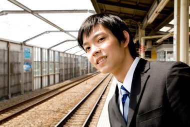 Asyalı iş adamı tren istasyonunda 