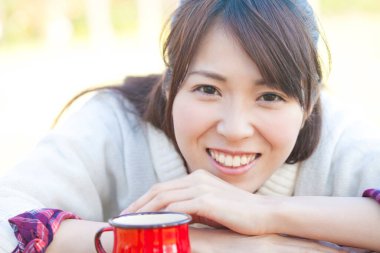 Genç bir kadın kahve fincanı içiyor.