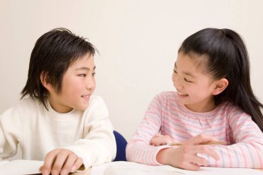 Sınıfta birbirine bakan Asyalı çocuklar.