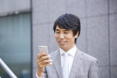 Akıllı telefon kullanarak Asyalı işadamını kapatın.