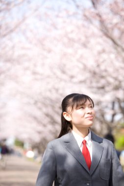 Genç bir kadın parkta yürüyor.