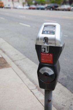 Şehir sokak kaldırımının yanındaki parkmetreyi gösteren yakın plan.