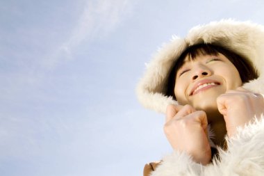 Genç Asyalı kadın kışlık ceket giyiyor.