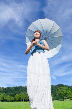 Yaz parkında beyaz şemsiyeli güzel Japon kadın.