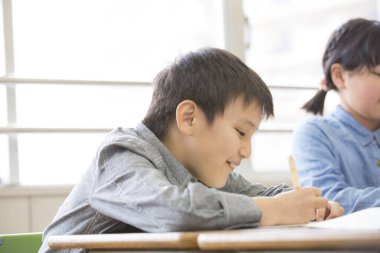 Asyalı öğrenciler sınıfta okuyor.