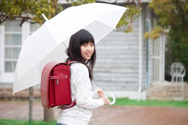 Şemsiyeli Asyalı kız öğrenci