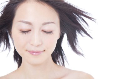 Gözleri beyaz arka planda kapalı Asyalı kadın.