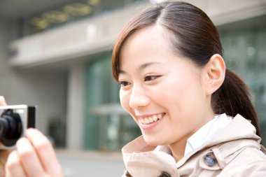 Kadın kamerada fotoğraf çekiyor.