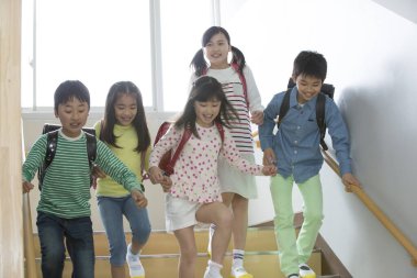 Sırt çantasıyla yürüyen bir grup öğrenci. 