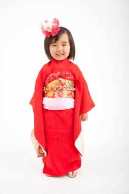 Geleneksel kırmızı kimono giyen küçük Asyalı kız 