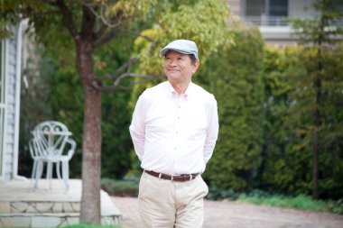 Şehir parkında dinlenen yaşlı Asyalı bir adamın portresi. 