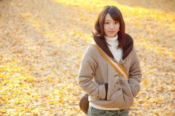 年轻美丽的亚洲女人在秋天的公园里摆姿势 — 图库照片