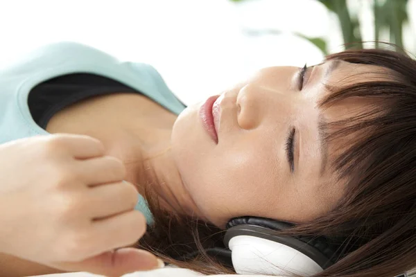 Belle Jeune Asiatique Femme Mensonge Écoute Musique Dans Casque Maison — Photo