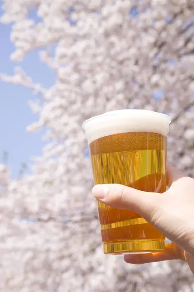Hand Hält Ein Glas Bier Auf Dem Hintergrund Des Frühlingsgartens — Stockfoto