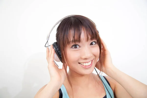 Güzel Genç Asyalı Kadın Kulaklıkla Müzik Dinliyor Evde Kameraya Gülümsüyor — Stok fotoğraf
