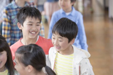 Ders arası koridorda yürüyen Asyalı öğrenciler. 