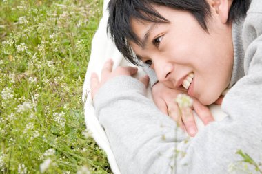 Parkta yatan Asyalı adam.